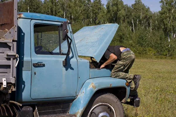 Άνθρωπος Επιδιορθώνει Ένα Παλιό Σοβιετικό Φορτηγό Ένα Πεδίο — Φωτογραφία Αρχείου