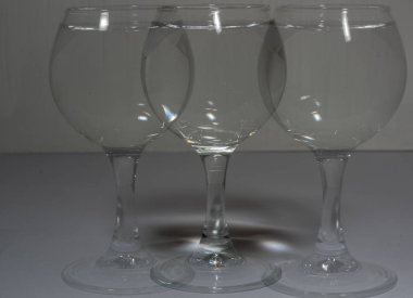 Bir bardak su farklı ışık ve bir gölge gibi kendi kopyaları ile