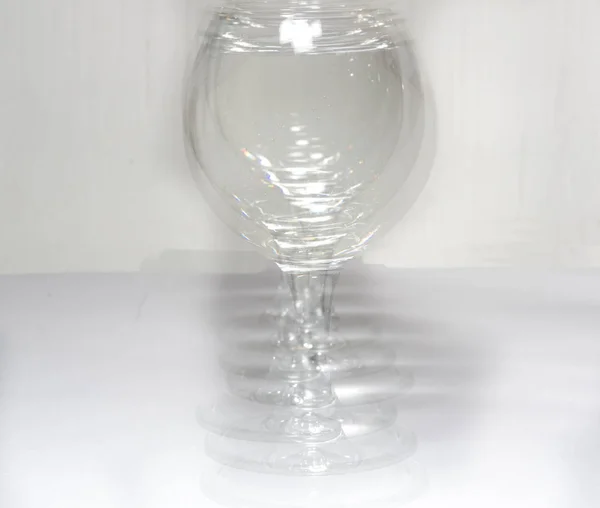 Bicchiere Con Acqua Luce Diversa Con Sue Copie Come Ombra — Foto Stock