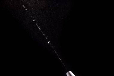 Siyah bir arka plan üzerinde havada burun için sprey püskürtülür