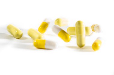 Beyaz ve sarı kapsül yalan ve beyaz bir arka plan karşı atlamak