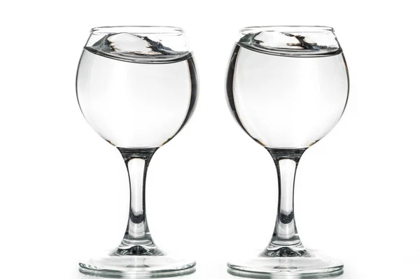 Dva Kulaté Brýle Prázdné Nebo Plné Vlnami Kapaliny Bílém Pozadí — Stock fotografie