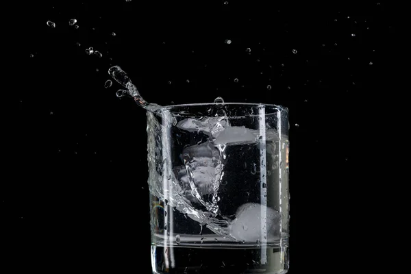 Salte Salpique Pedaço Gelo Jogado Copo Transparente Com Água Fundo — Fotografia de Stock