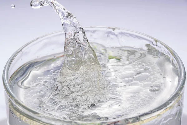 waves and a splash from the water in a round glass with oil and syrup