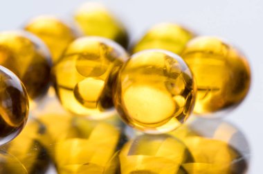 Balık yağı, omega 3 içeren sarı ve turuncu ilaç kapsül