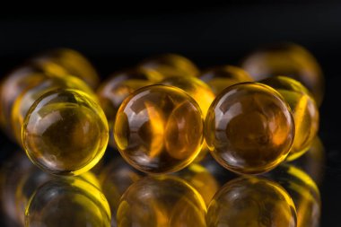 Balık yağı, omega 3 içeren sarı ve turuncu ilaç kapsül
