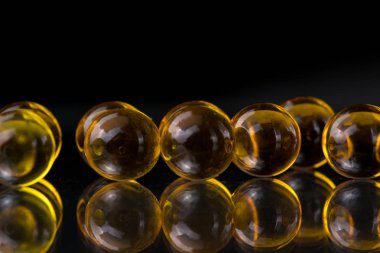 Balık yağı, omega 3 içeren sarı ve turuncu ilaç kapsül