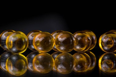 Balık yağı, omega 3 içeren sarı ve turuncu ilaç kapsül