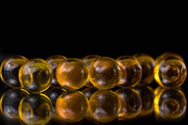 Balık yağı, omega 3 içeren sarı ve turuncu ilaç kapsül