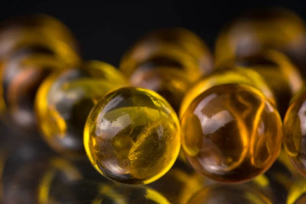 Yellow and orange medicine capsules containing fish oil, omega 3