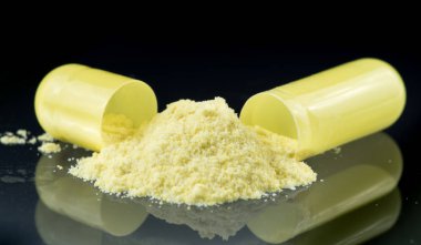 Antibiyotik kapsül, sarı tozu ve tuz kristallerinin içeriğini