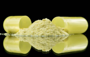 Antibiyotik kapsül, sarı tozu ve tuz kristallerinin içeriğini