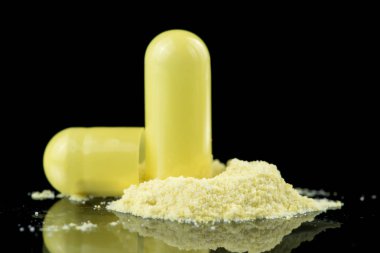 Antibiyotik kapsül, sarı tozu ve tuz kristallerinin içeriğini