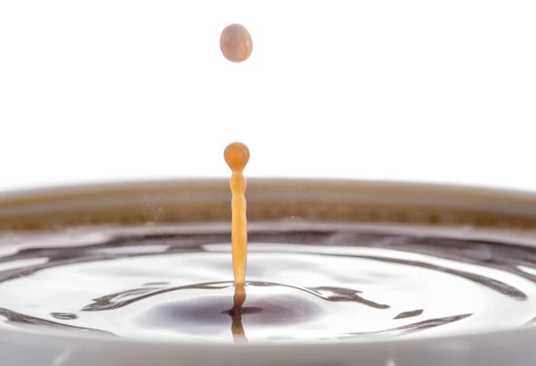 コーヒー クリーム 白い背景の上のコーヒーの表面にミルクを一滴からスプラッシュ — ストック写真