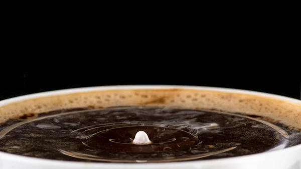 コーヒー クリーム 黒背景のコーヒーの表面にミルクを一滴からスプラッシュ — ストック写真