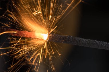 Maytap yanan kıvılcımlar bir sürü, siyah bir arka plan kadar yakın