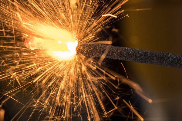 Burning sparkler close up on a black background, a lot of sparks