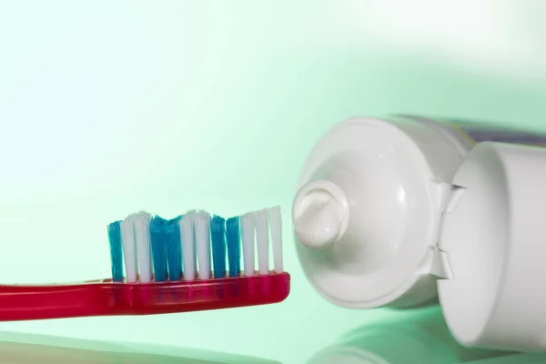 白色または着色された背景に歯ブラシに歯磨き粉 — ストック写真