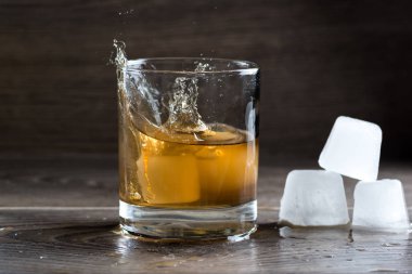 Bardak viski ve düşen buz sıçramasına