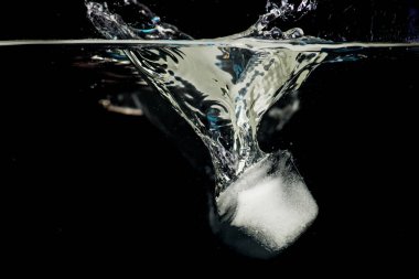 Siyah bir zemin üzerine su içine atılmış buz topakları