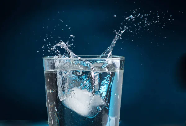 Salpicadura Trozo Hielo Que Cae Vaso Agua Sobre Fondo Oscuro — Foto de Stock