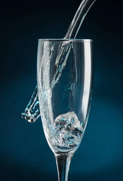 Espirrar Uma Taça Champanhe Contra Queda Água Fundo Azul Escuro — Fotografia de Stock