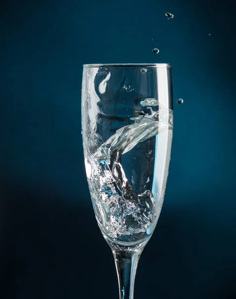 Salpicadura Una Copa Champán Contra Caída Agua Sobre Fondo Azul — Foto de Stock