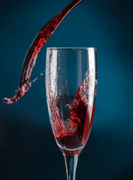 Plaska Ett Champagneglas Från Att Falla Rött Vin Mörkblå Bakgrund — Stockfoto