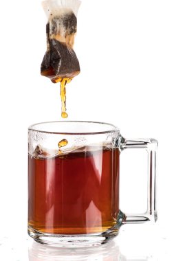 Beyaz zemin üzerine saydam bir kupa çay şekerli bir çay çanta yapmak