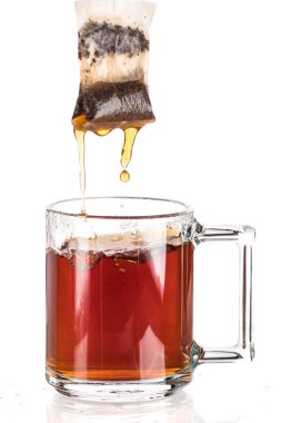 Beyaz zemin üzerine saydam bir kupa çay şekerli bir çay çanta yapmak