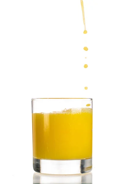 Menuang Jus Jeruk Dalam Gelas Transparan Pada Latar Belakang Putih — Stok Foto