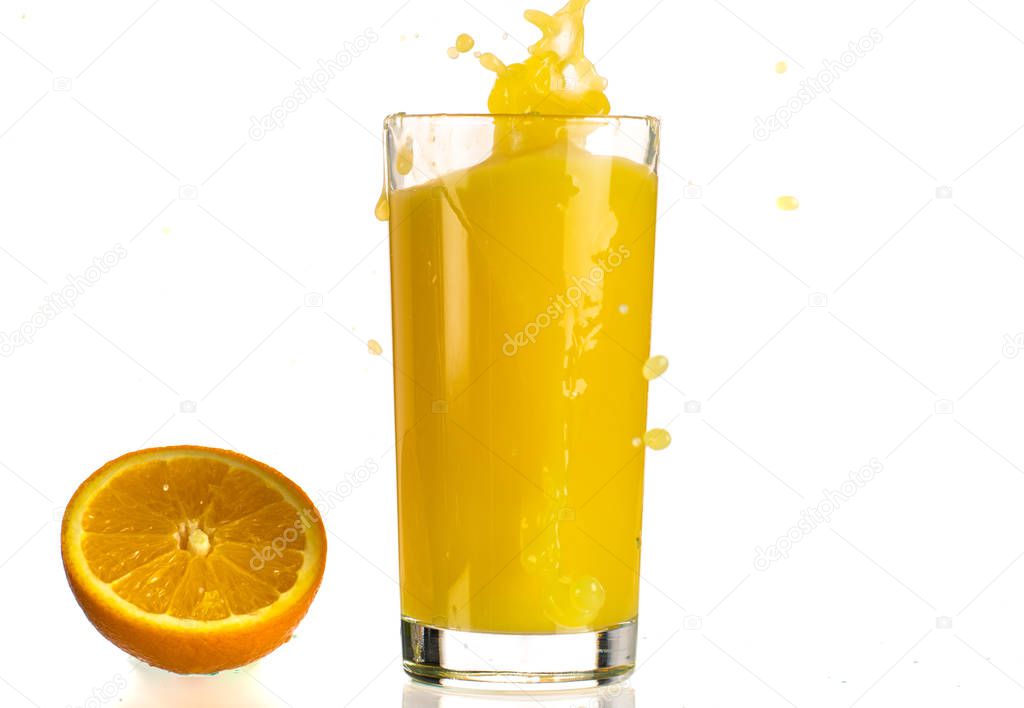 Pouring orange juice into a transparent glass on a white background