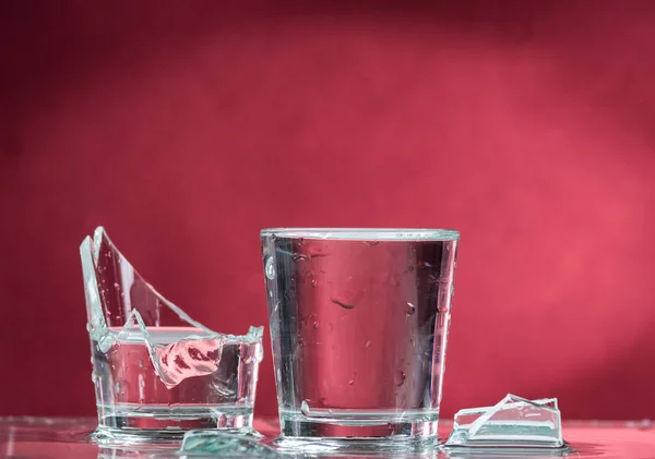 Falling Small Glasses Spilling Water Red Background — Stock Photo, Image