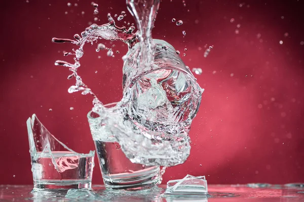 Cadere Piccoli Bicchieri Versare Acqua Uno Sfondo Rosso — Foto Stock