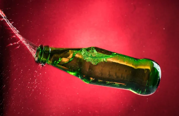 Flying Falling Crashing Green Bottle Red Gradient Background Shards Splashes — Stock Photo, Image