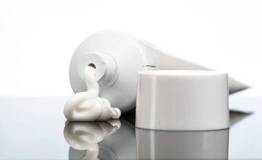 Jel, krem, dış kullanım için merhem bir tüp ve beyaz bir arka plan yanındaki kapak dışarı sıkılmış