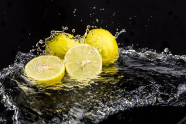 Tam kireç ve yarımlar, su sıçratarak yakın plan dilimler.