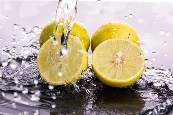 Tam kireç ve yarımlar, su sıçratarak yakın plan dilimler.