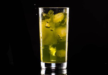 siyah bir arka plan üzerinde bir bardak buz ile nane şurubu ile portakal kokteyli