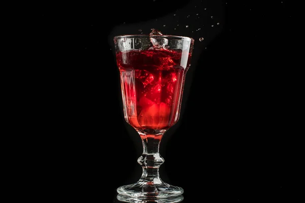 白または黒の背景にスプラッシュを持つ赤ワインのグラス — ストック写真