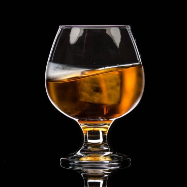 Buz, bir dalga ve küçük bir sıçrama ile viski brendi yuvarlak bir bardak