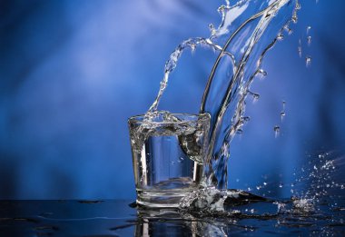 Votka ile Cam ve renkli bir arka plan üzerinde büyük bir sıçrama