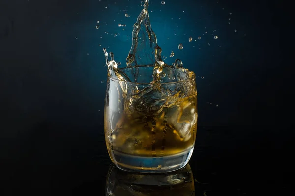 Een Glas Whisky Met Ijs Een Donkere Kleurenfoto Met Spatten — Stockfoto