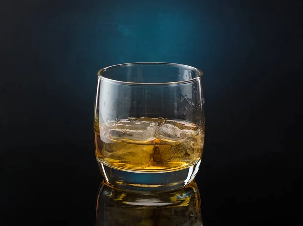 Premium Photo  Glass with whiskey and falling ice cube with splashes