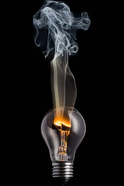 broken light bulb and smoke from a burning spiral on a black background