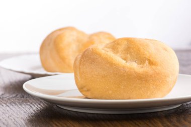 Beyaz bir tabakta çörek pişirmek ya da beyaz arka planda şeffaf bir torba içinde