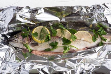 Balık nehri alabalığı folyoda ve baharatlar pişirmeye hazır.