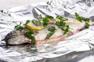 Balık nehri alabalığı folyoda ve baharatlar pişirmeye hazır.