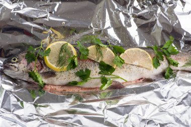 Balık nehri alabalığı folyoda ve baharatlar pişirmeye hazır.