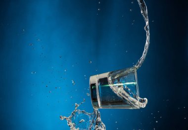 Düşen bardaklar, mavi arka planda votka ve sprey